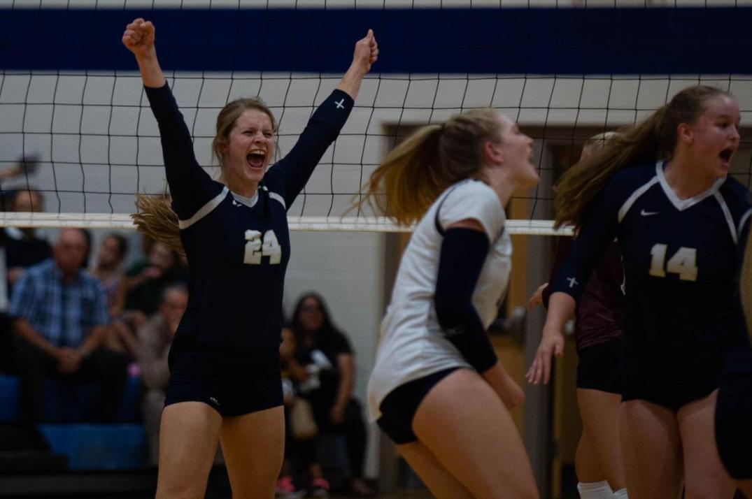 Josie Puelz cheering with her hands held high